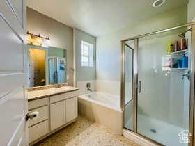 Primary Bathroom featuring vanity, a stall shower, a garden tub, and light flooring