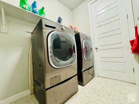 Laundry area featuring separate washer and dryer and light floors