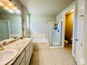 Primary Bathroom with a shower stall, a bath, double vanity, and light floors