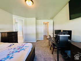Primary Bedroom featuring dark carpet and an office area