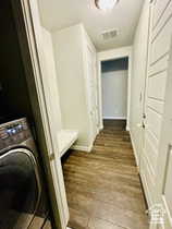 Laundry Hall area featuring washer / clothes dryer and dark wood finished floors