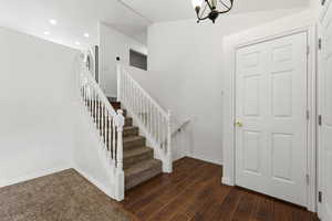 Stairs featuring hardwood / wood-style floors and hanging lights