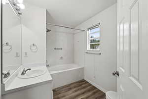 Full bathroom featuring vanity, bathing tub / shower combination, and dark wood finished floors