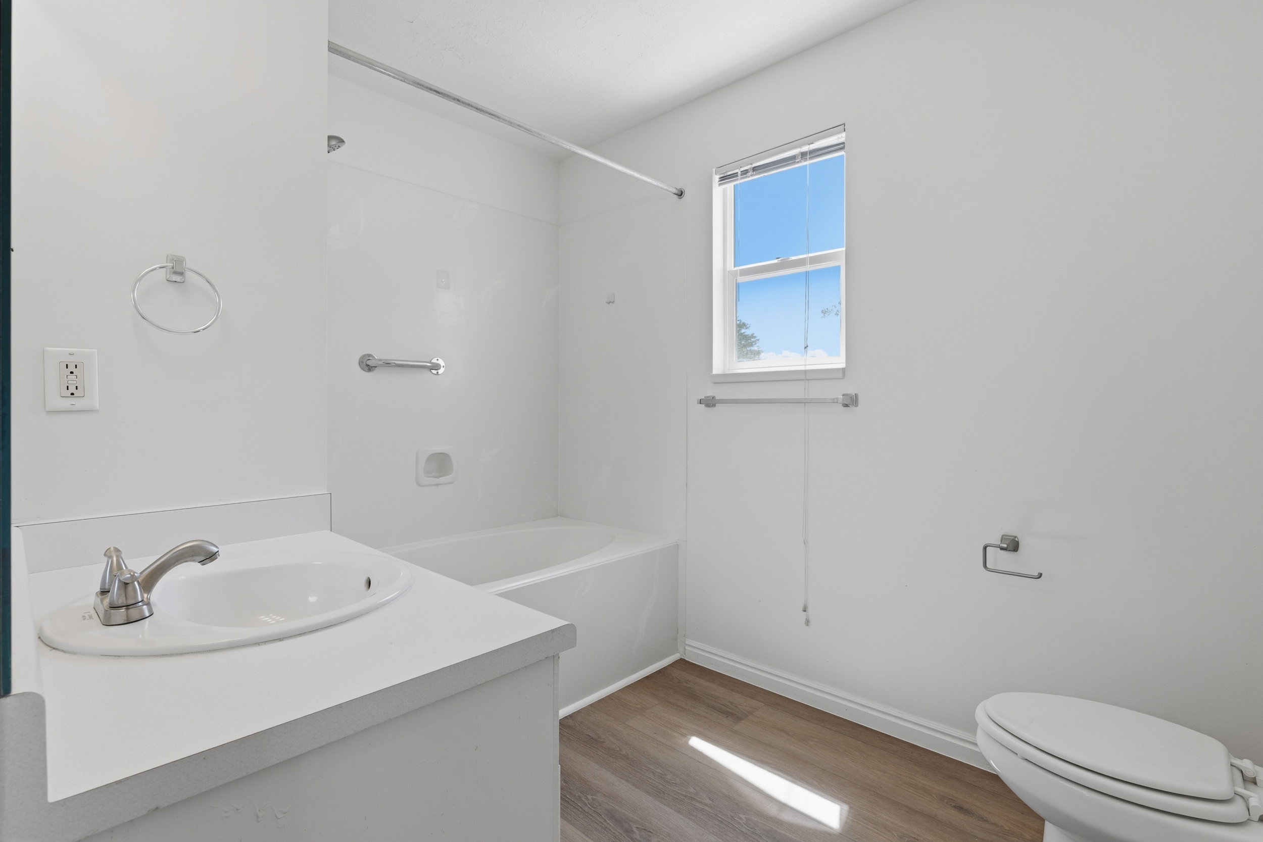 White vanity with integrated sink and brushed nickel faucet