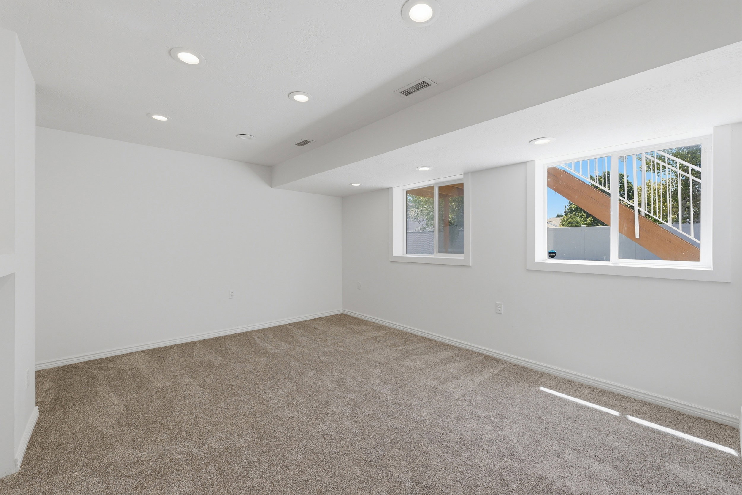 Carpeted 2ND LIVING room featuring recessed lighting, two windows, and white painted walls