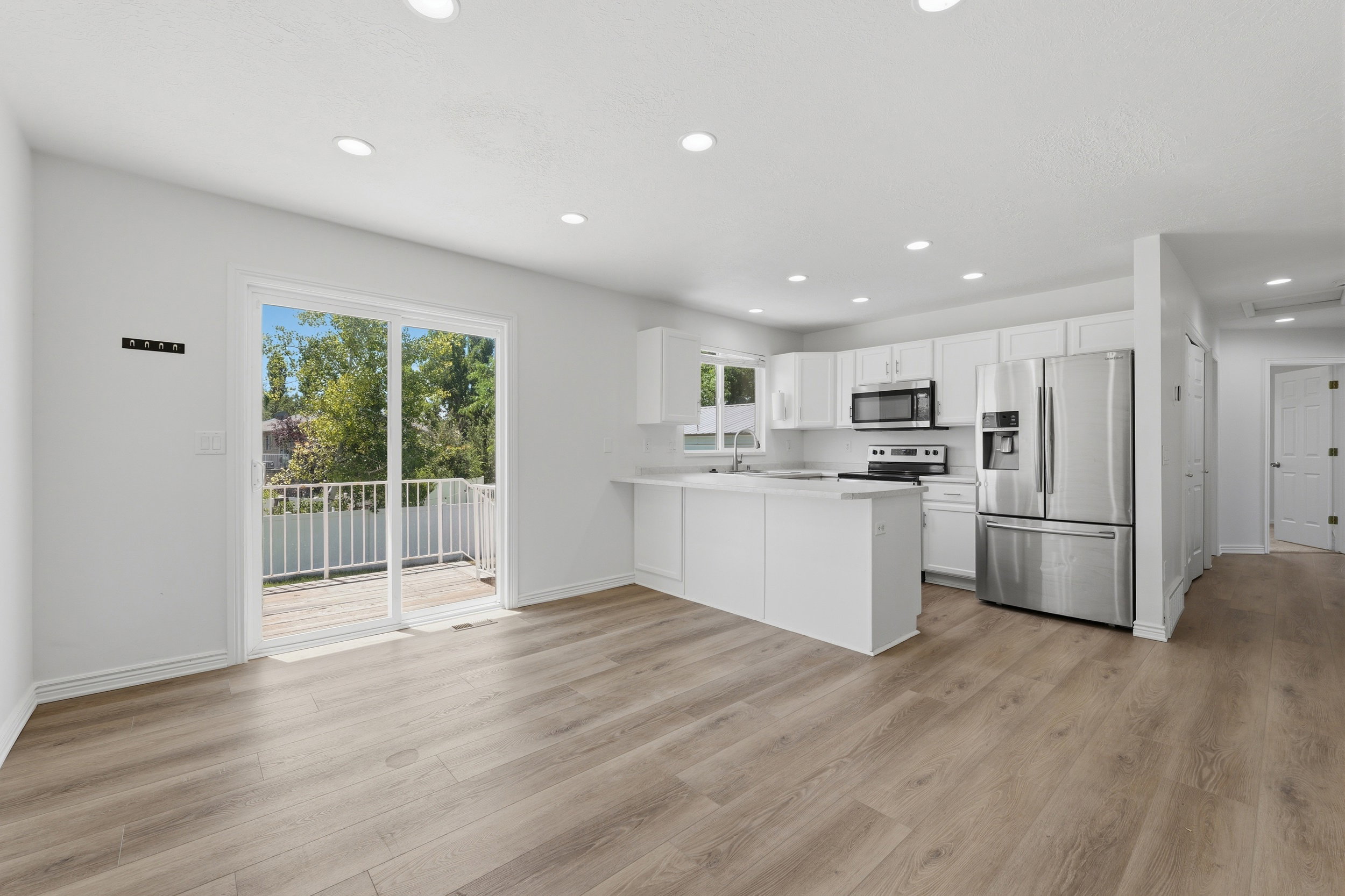 Open-concept interior featuring light wood-finish flooring and white walls