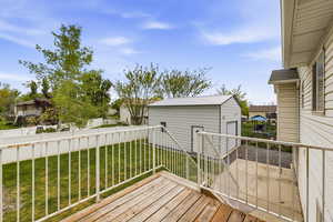 Wooden deck featuring an outbuilding and a residential view