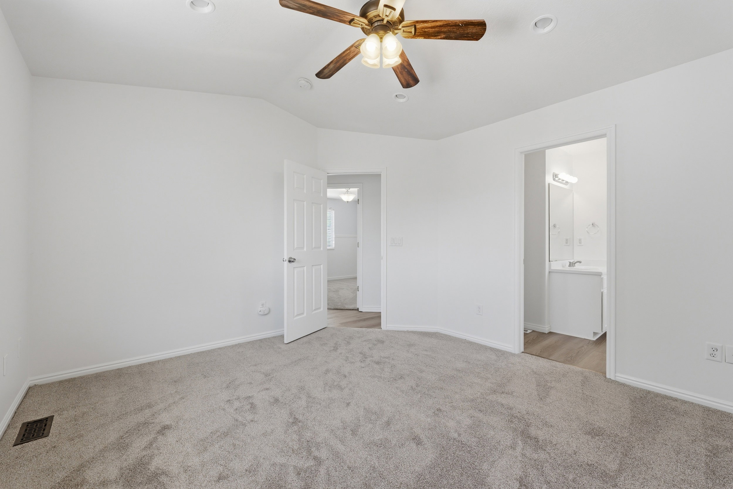 Spacious PRIMARY room featuring neutral carpeting, a ceiling fan with integrated lighting, and recessed ceiling lights