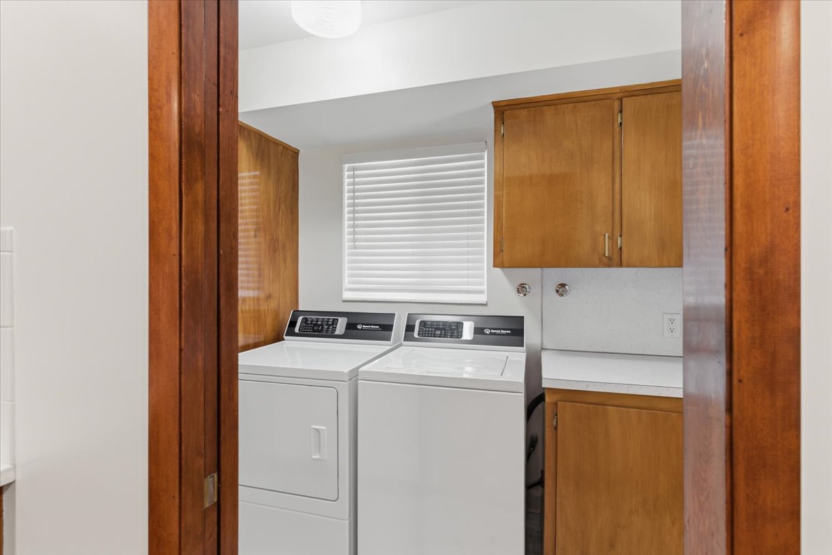 Laundry area with cabinet space and washer and clothes dryer