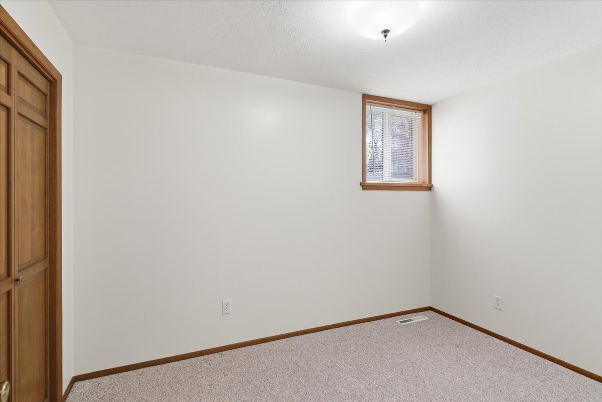 Carpeted spare room featuring a textured ceiling and baseboards