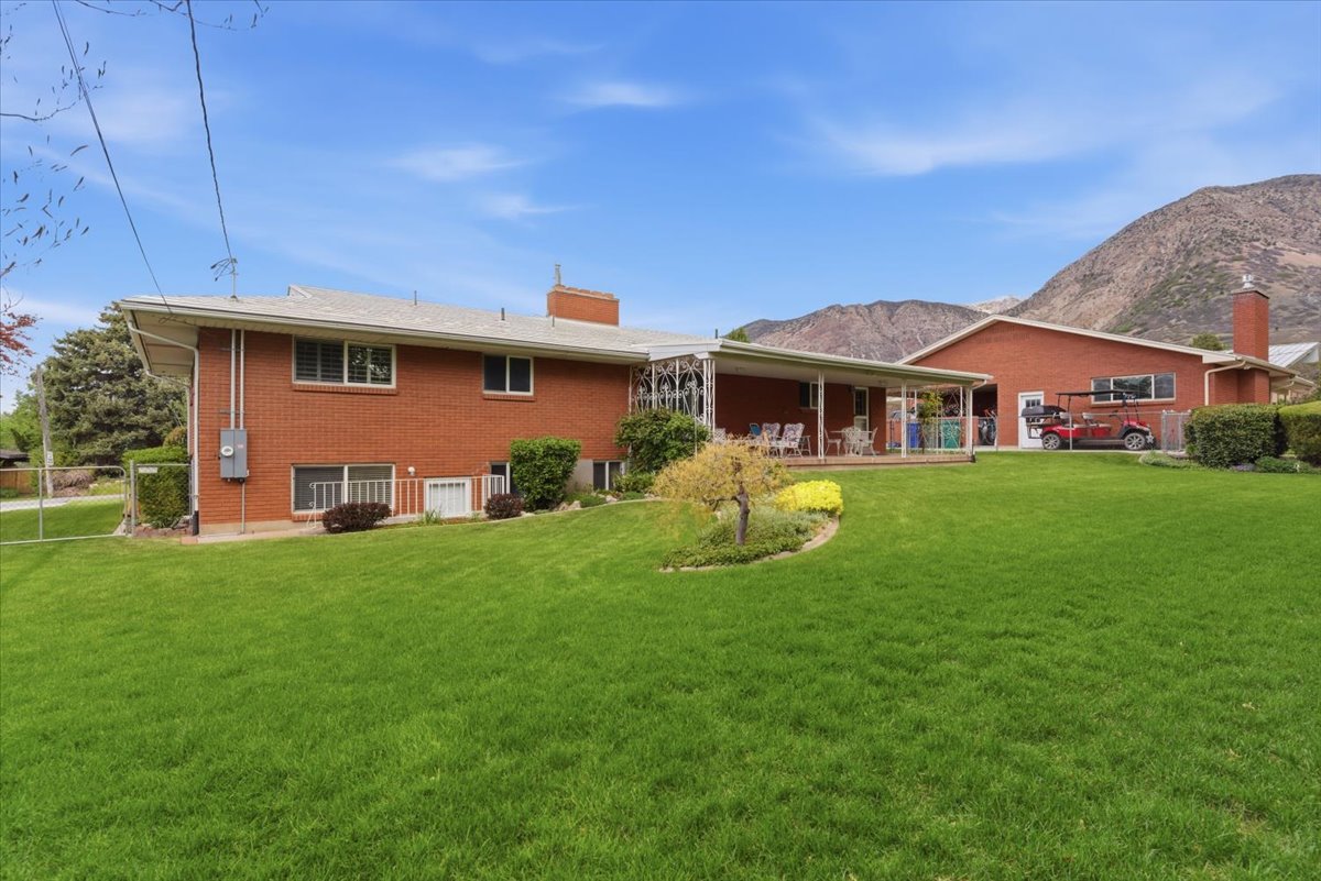 Back of house with a chimney, brick siding, and a mountain view