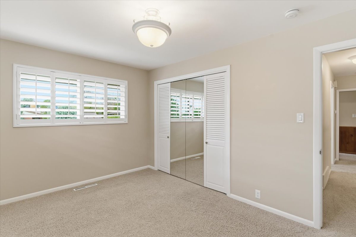 Unfurnished bedroom featuring light colored carpet and a closet