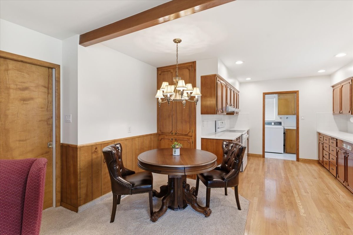 Dining room with washer / clothes dryer, a chandelier, and wooden walls