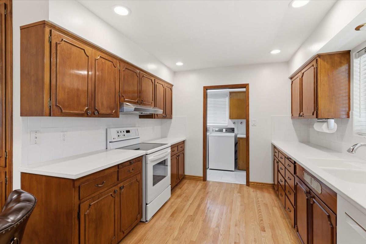 Kitchen featuring electric stove, backsplash, light wood-style flooring, wood finish cabinets, and recessed lighting