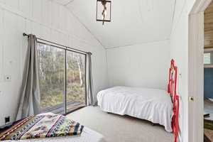 Carpeted bedroom featuring wood walls, access to outside, multiple windows, and a vaulted wooden ceiling