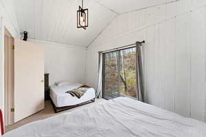 Bedroom with carpet floors and wood walls