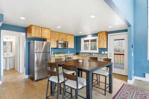 Kitchen featuring light wood finish cabinets, stainless steel appliances, light wood-type flooring, recessed lighting, and light stone counters