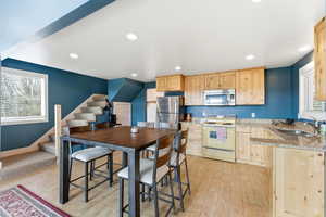 Kitchen with light wood finish cabinets, stainless steel appliances, light wood-style flooring, and recessed lighting