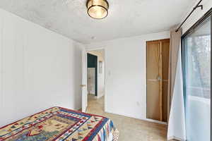 Unfurnished bedroom with light wood-style flooring and a textured ceiling