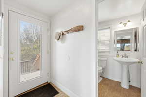 Doorway featuring wood finished floors and baseboards