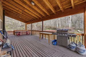 Wooden deck featuring area for grilling