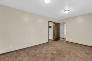 Empty room featuring parquet flooring and baseboards