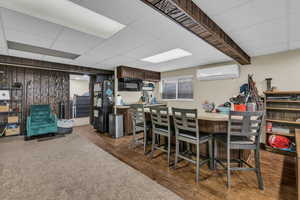Dining room with a paneled ceiling, dark wood finished floors, and a mini split for heating / cooling