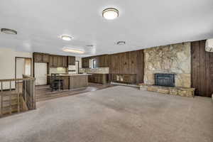 Unfurnished living room with dark carpet, baseboard heating, and wood walls