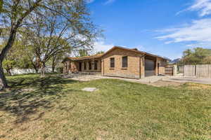 Rear view of property with brick siding, a garage, and driveway