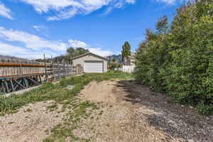 View of yard featuring an outbuilding, a detached garage, driveway, and a mountain view