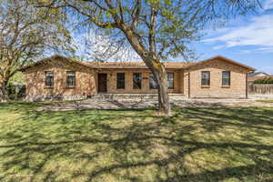 View of front of home featuring brick siding and a patio area