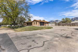 View of front of property with concrete driveway, brick siding, a mountain view, and an attached garage
