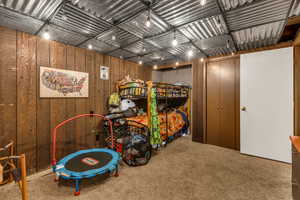 Bedroom featuring carpet flooring and wood walls