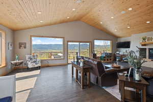 Living area featuring hardwood / wood-style floors, a high wooden ceiling, recessed lighting, and a glass covered fireplace
