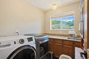 Laundry area with separate washer and dryer, a textured ceiling, and cabinet space