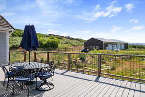 Deck with outdoor dining area and an outbuilding
