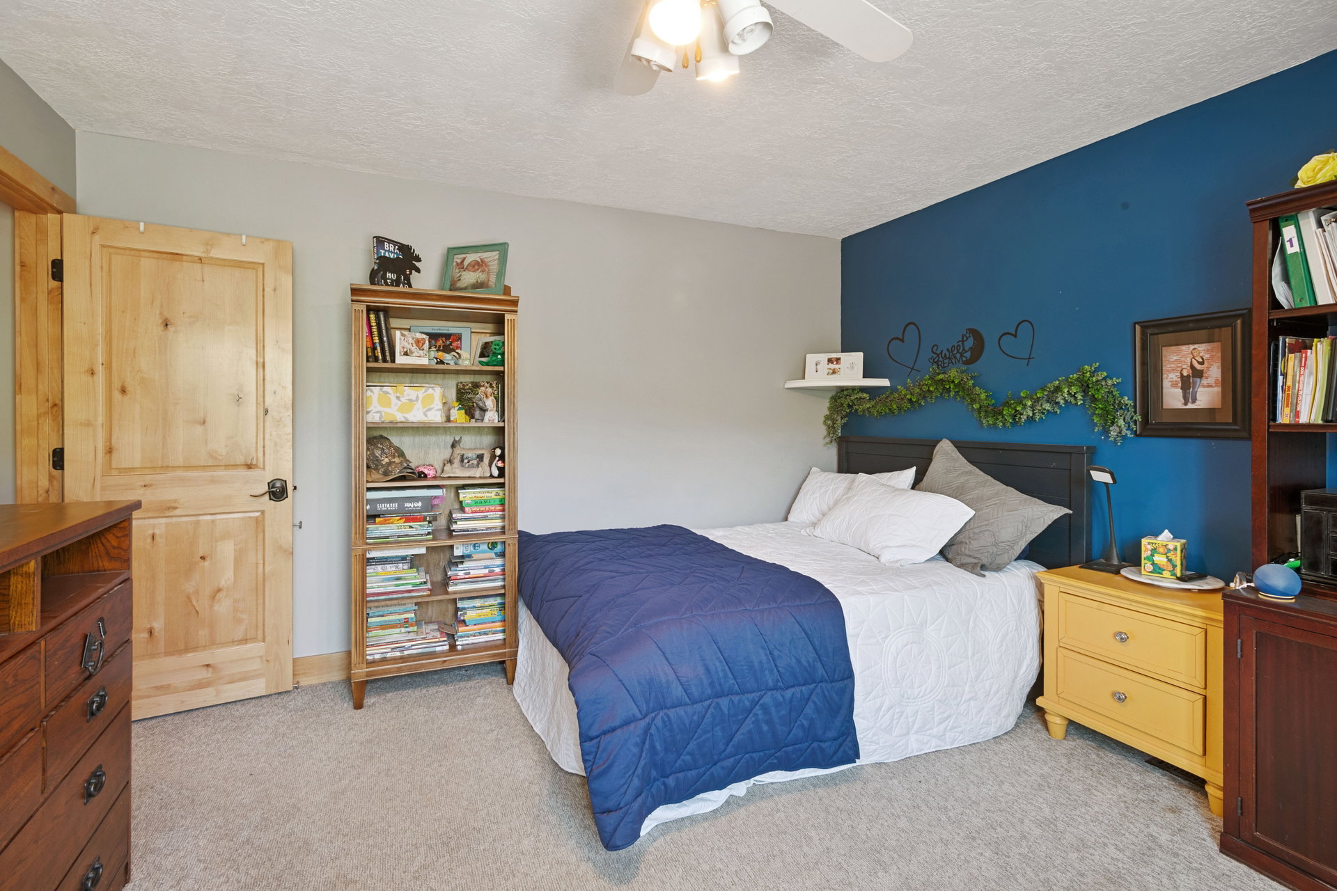 Bedroom featuring light carpet, ceiling fan, and a textured ceiling
