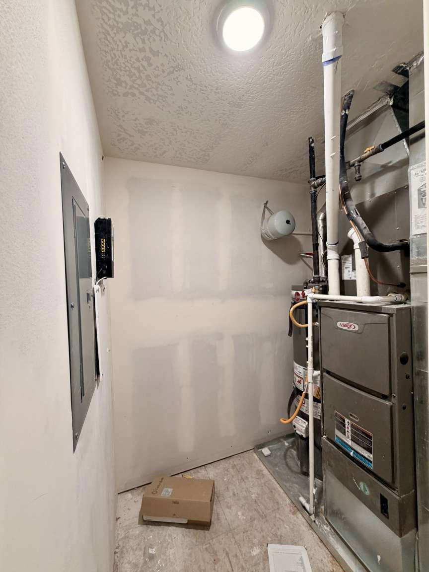 Utility room featuring a Lennox furnace, water heater, electrical panel, recessed ceiling light, and textured ceiling finish