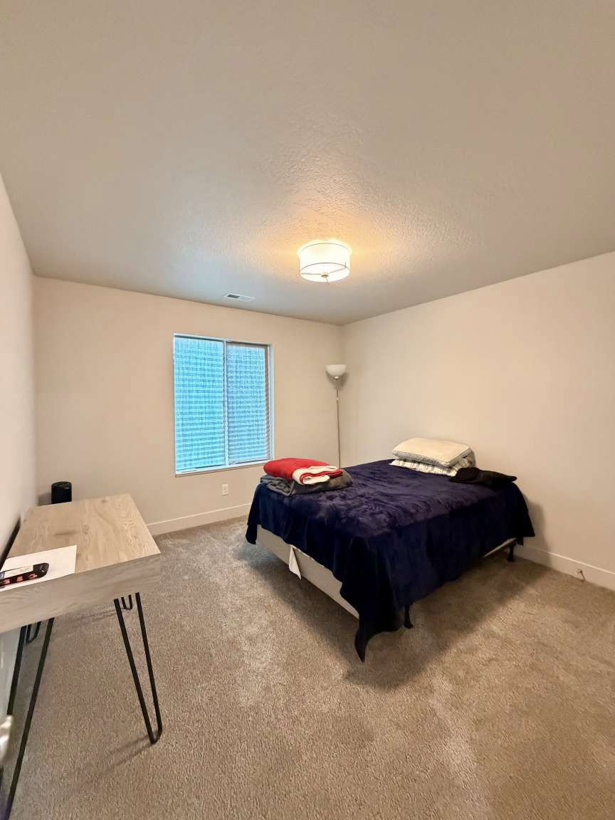 Carpeted room featuring a window with blinds, a flush mount ceiling light fixture, and neutral wall tones