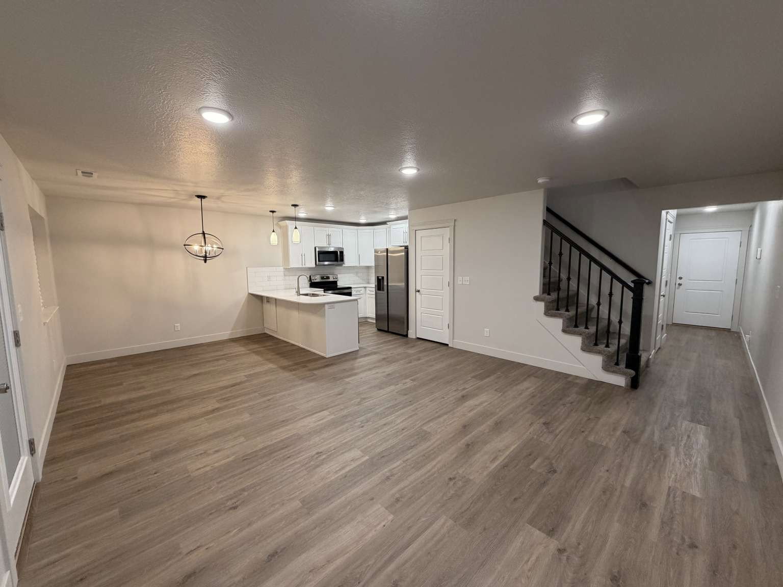 Open-concept living space with wood-finish flooring extending throughout