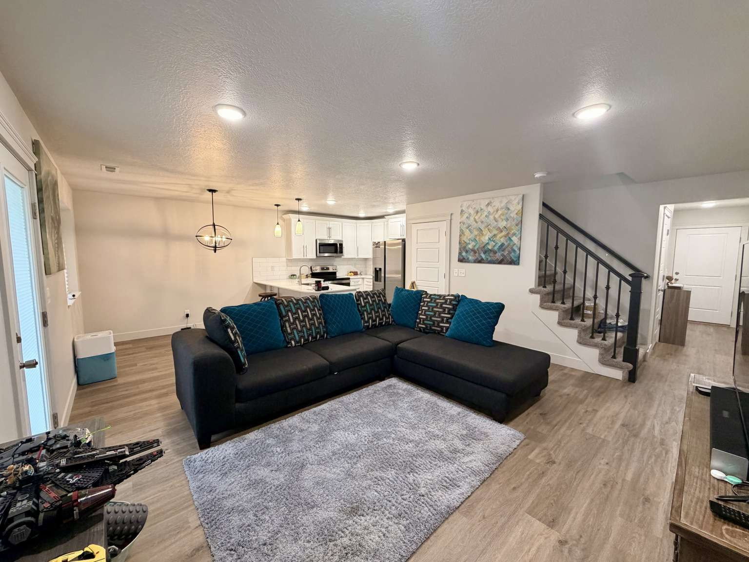 Open-concept living space featuring wood-finish flooring, recessed lighting, and a modern light fixture