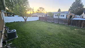 Yard at dusk featuring a fenced backyard