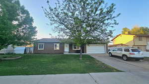 Ranch-style home featuring concrete driveway and a garage