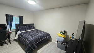Bedroom with light wood-style floors and baseboards