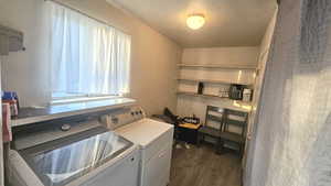 Laundry room featuring washing machine and clothes dryer and dark wood finished floors