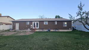 Back of property with a fenced backyard, french doors, and a patio