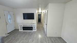 Unfurnished living room featuring light wood-style flooring and baseboards