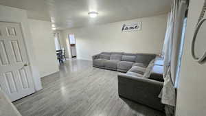 Living area with light wood-style flooring and baseboards