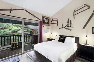 Bedroom featuring lofted ceiling and access to outside
