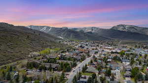 Aerial view of residential area with a mountain backdrop and property parcel outlined
